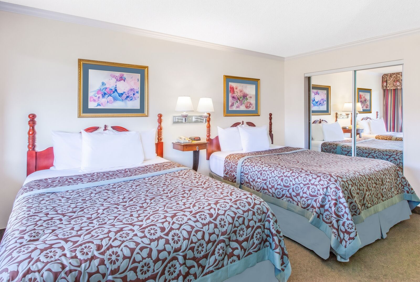 Guest room with two beds and mirrored closet doors
