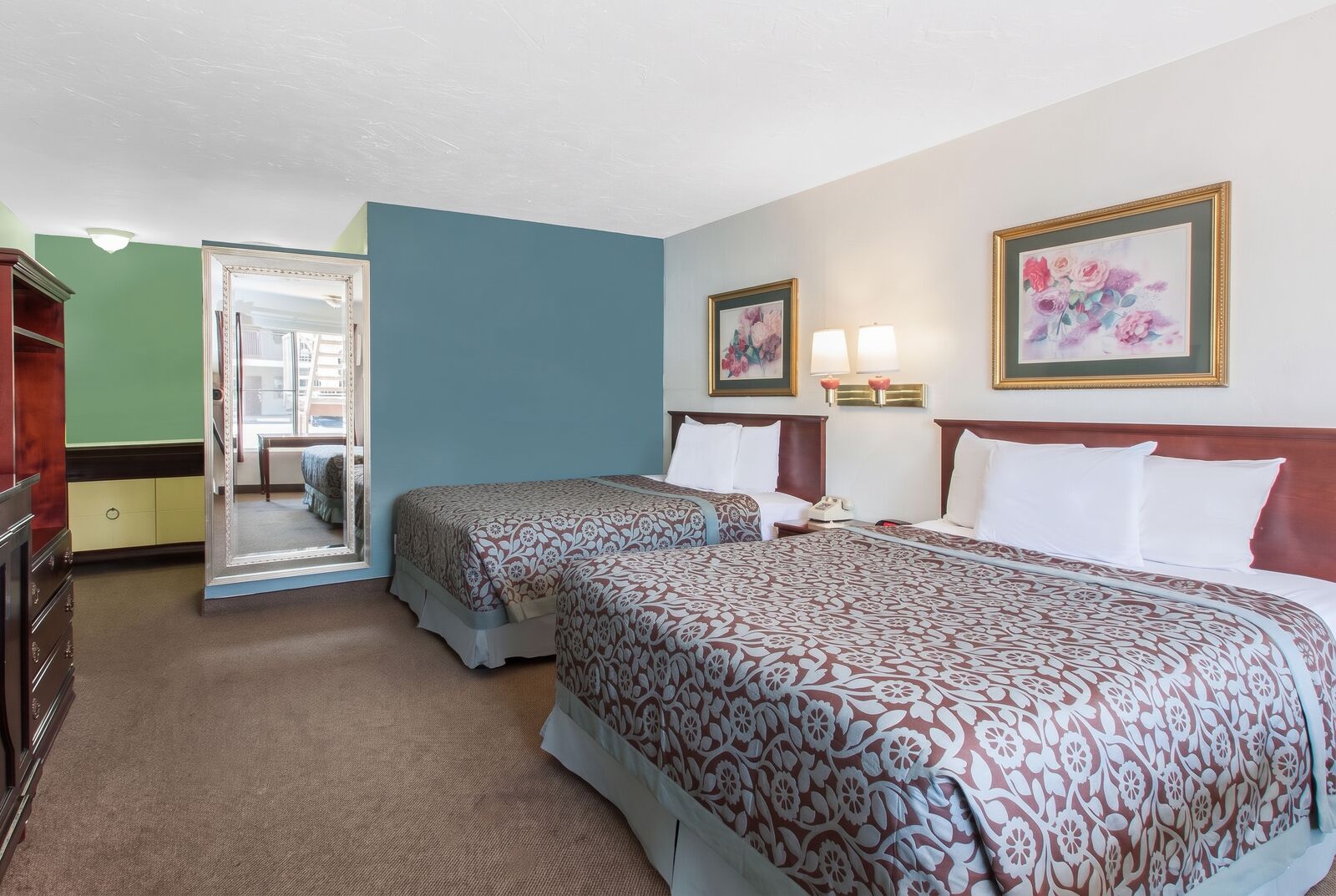 Guest room with two beds and a blue accent wall
