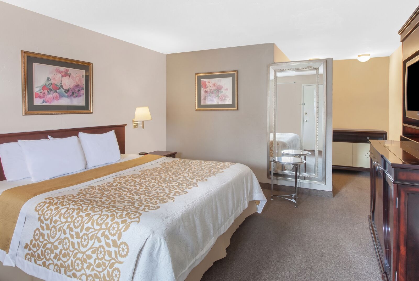 Guest room with one large bed, a desk and a dresser